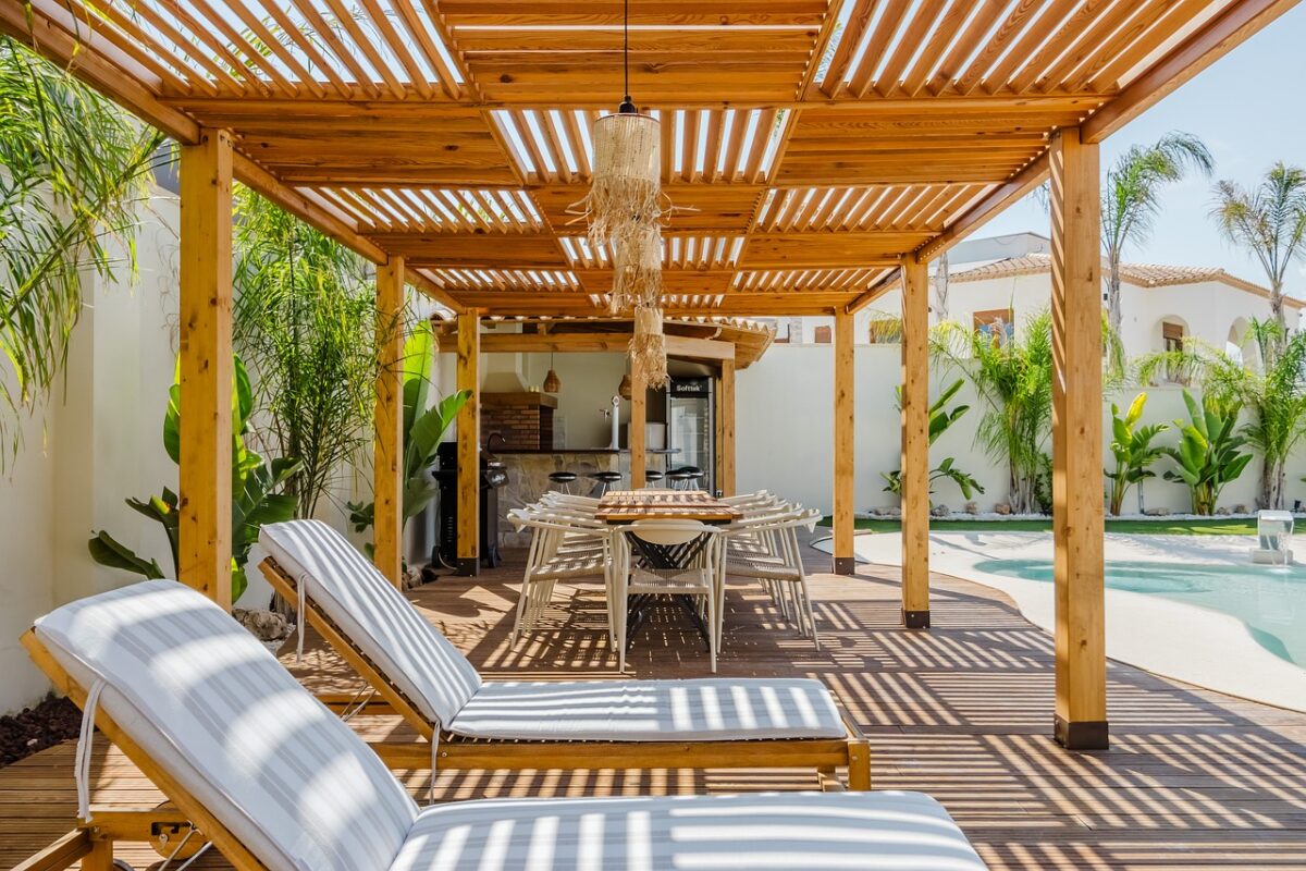Udržovaná dřevěná pergola s ošetřeným dřevem nad terasou